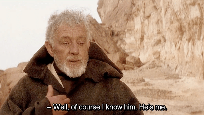 Screenshot of Obi Wan Kenobi in Star Wars: A New Hope. An old white-haired man with a white beard, wearing a brown cloak, gestures toward his chest. White text at the bottom of the image reads: "Well, of course I know him. He's me."